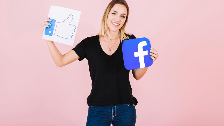 kobieta trzymająca logo facebooka i like